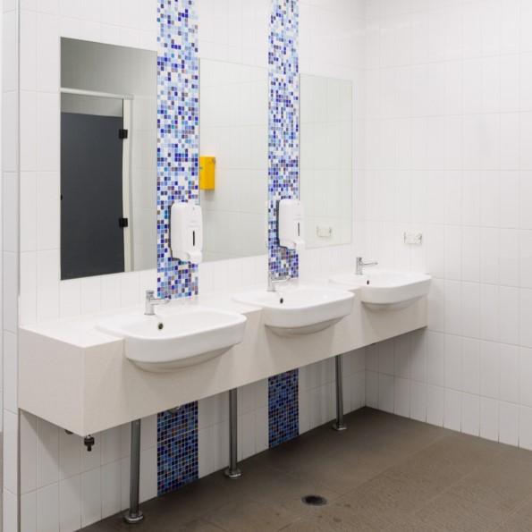 A photo of three sinks inside a bathroom