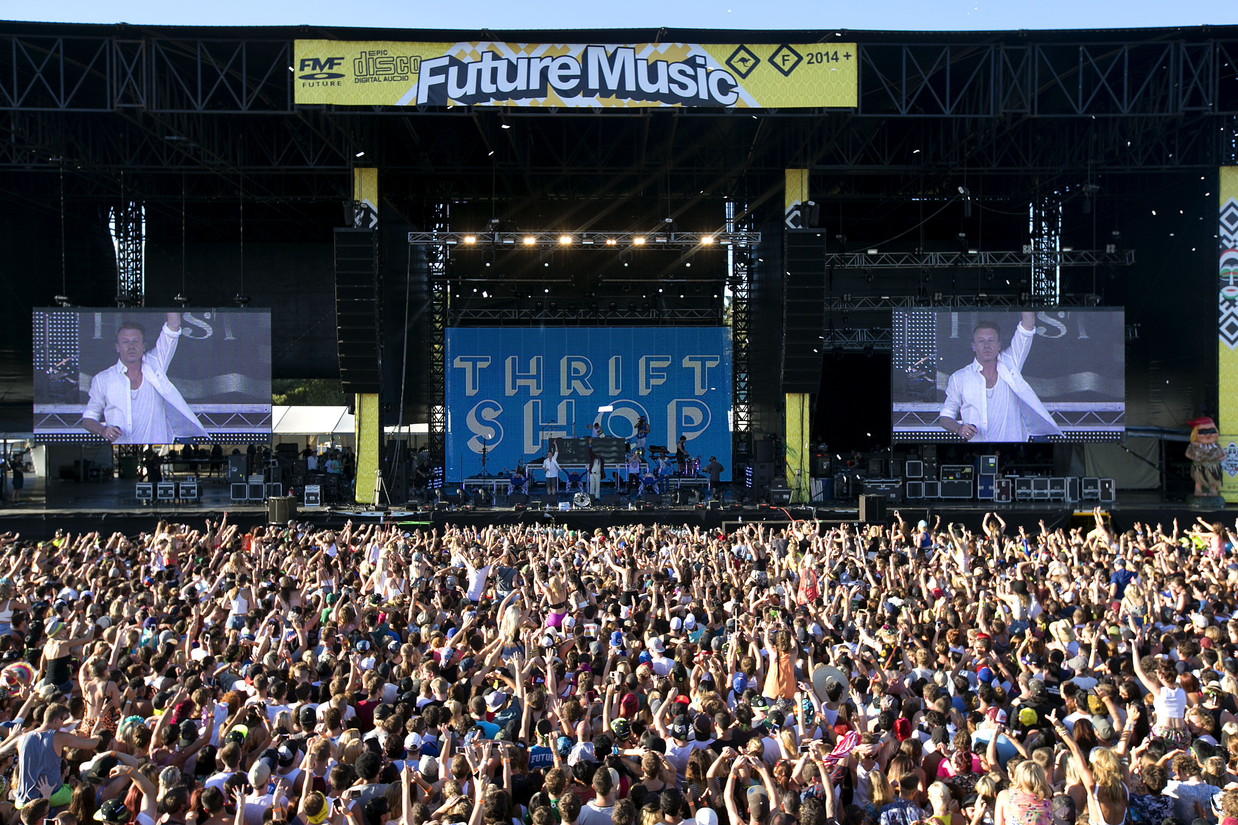 A photo of a large crowd gathered before a large music stage