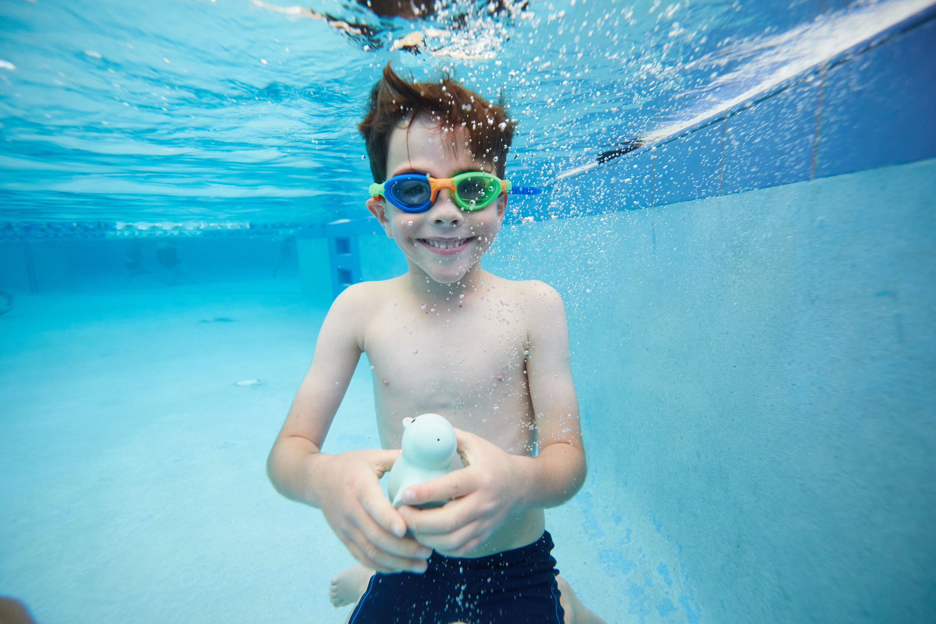 Underwater view of young boy smiling at the camera