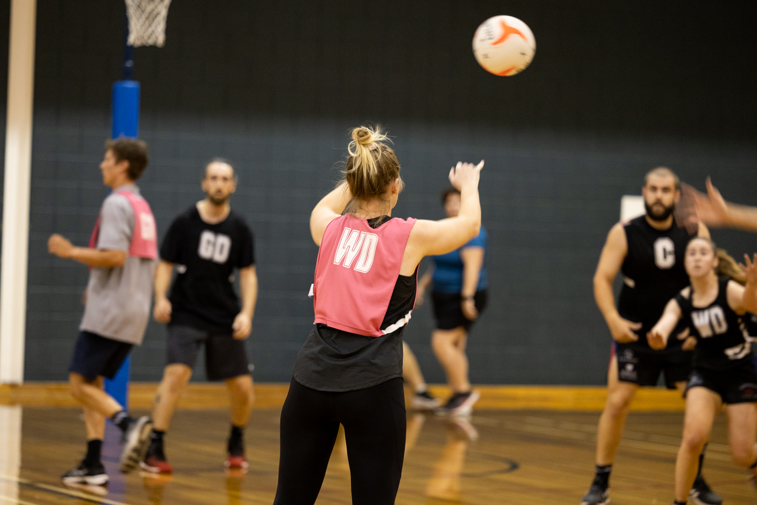 Rear view of netballer releasing a pass